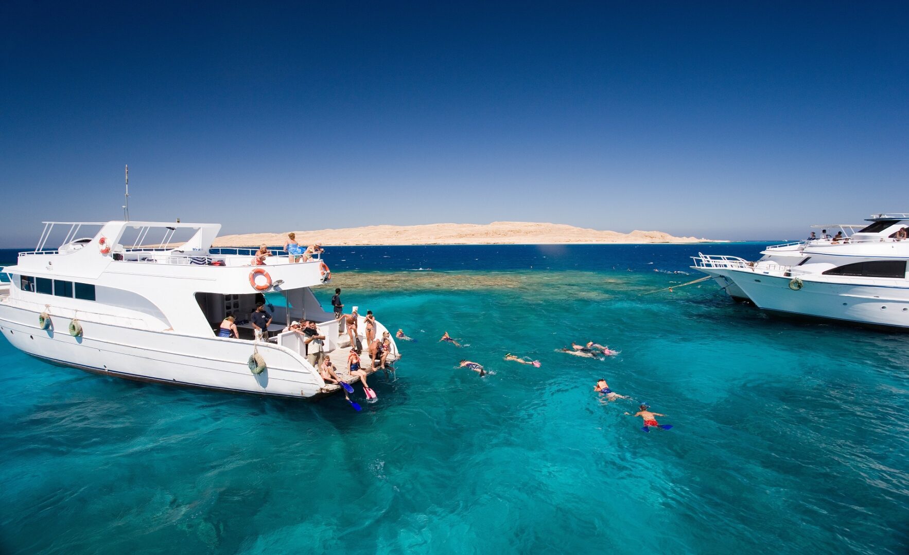 Boats and snorkellers in the turquoise Red Sea off Hurghada